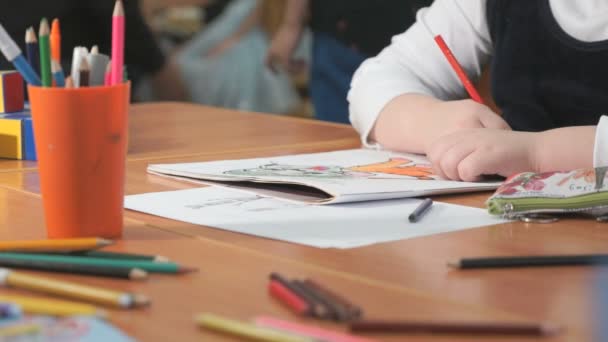 Little girl draws the pictures using color pencils — Stock Video