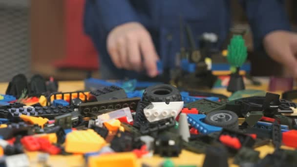 Manos de niño desconocido jugando con el kit de construcción — Vídeos de Stock