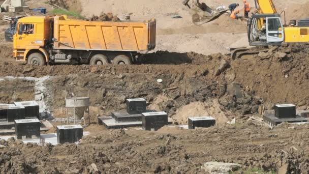 Excavadora con cubo empuja camión volquete de barro — Vídeos de Stock