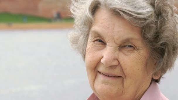 Портрет усміхненої зрілої старої жінки на відкритому повітрі — стокове відео
