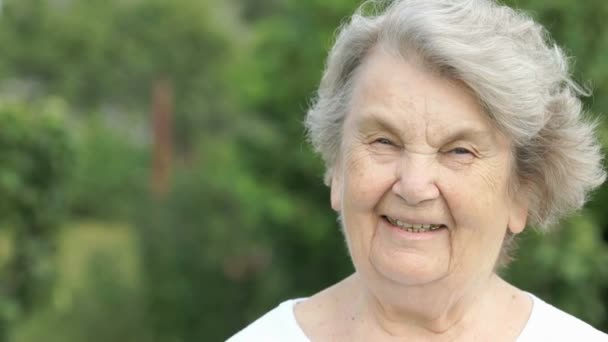 Портрет улыбающейся пожилой женщины на открытом воздухе — стоковое видео