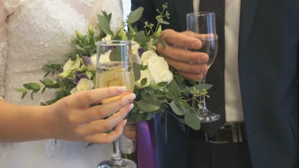 Bride and groom holding glasses of wine. Close-up — Stock Video