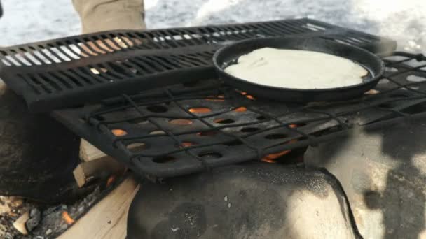 Russian pancakes on frying pan on bonfire — Stock Video
