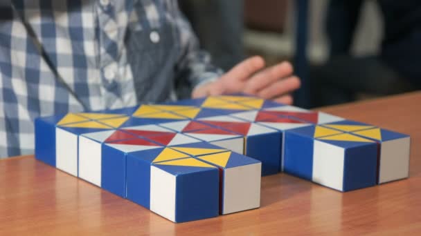 Petit garçon recueillant modèle en utilisant des cubes colorés — Video