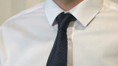 Bilinmeyen bir adam kravat kamera önünde sıkma