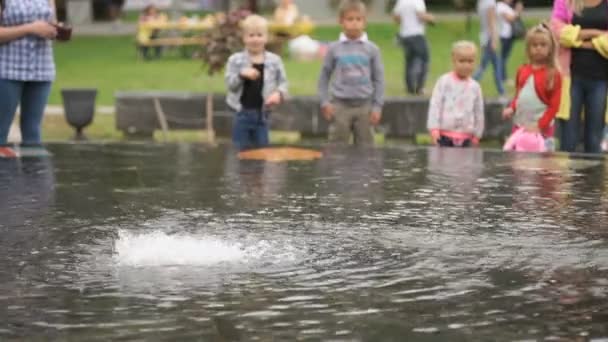 Lille dreng smide mønter penge i midten af springvandet – Stock-video