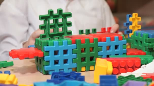 Handen van onbekende kind spelen met het bouwen van kit — Stockvideo