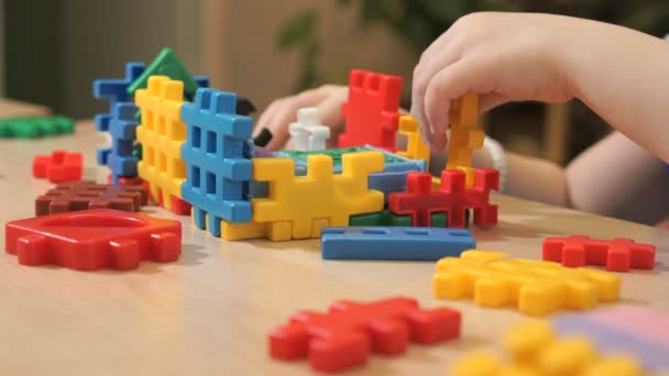 Manos de niño desconocido jugando con el kit de construcción — Vídeos de Stock