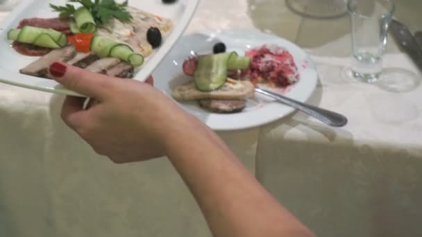Mujer toma plato de comida y pone sobre la mesa — Vídeos de Stock