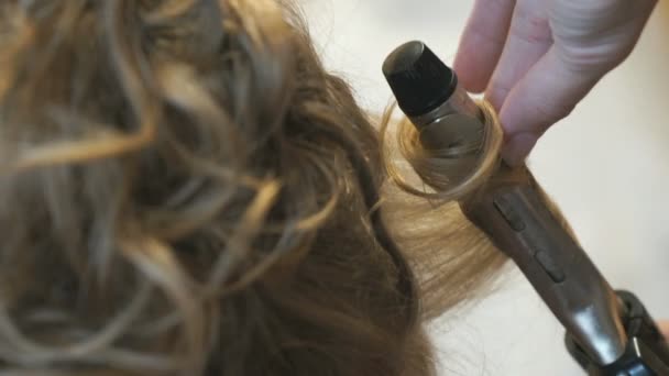 Styliste fait des boucles aux cheveux bruns en utilisant un curling — Video