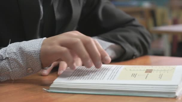 Colegial desconocido vestido de traje lee libro — Vídeos de Stock