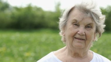 Olgun yaşlı kadın açık havada gülümseyen portresi