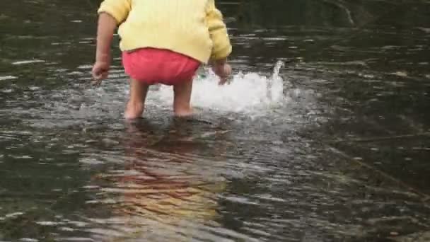 Petite fille pieds nus recueille des pièces dans la fontaine — Video