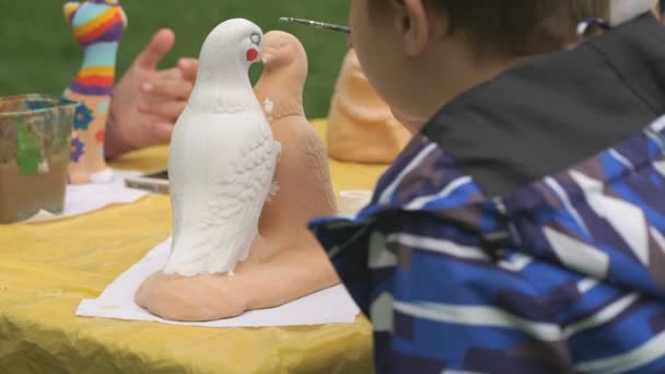 Brosses à peindre pour enfants sur la figure en argile à l'extérieur — Video