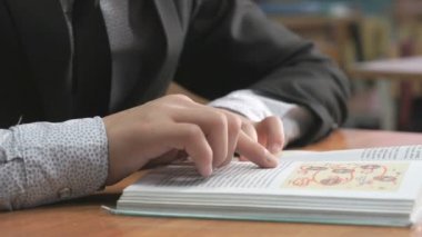 Takım elbise giymiş bilinmeyen okul çocuğu kitap okur