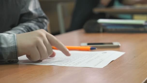 Étudiant inconnu lit le texte sur la feuille — Video