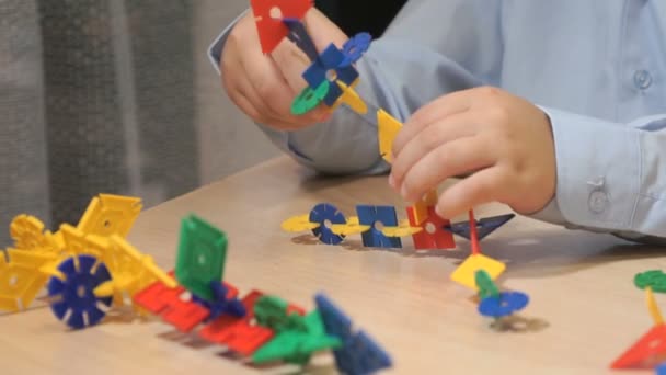 Руки неизвестного мальчика, играющего со строительным комплектом — стоковое видео