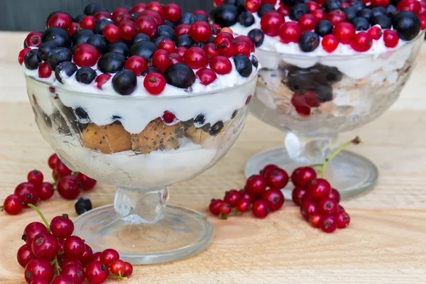 Sobremesa com creme e bagas frescas (groselhas vermelhas e pretas, mirtilo ) — Fotografia de Stock