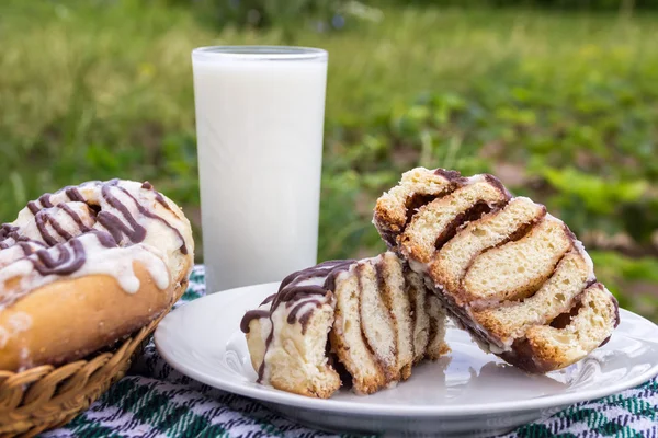 Panini alla cannella fatti in casa con glassa di crema di formaggio e glassa al cioccolato e bicchiere di latte — Foto Stock