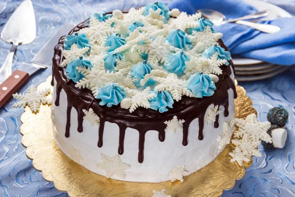 美丽的奶油蛋糕装饰着巧克力的泄漏，奶油和糖膏，对背景板、 茶匙和托盘刀的雪花 — 图库照片