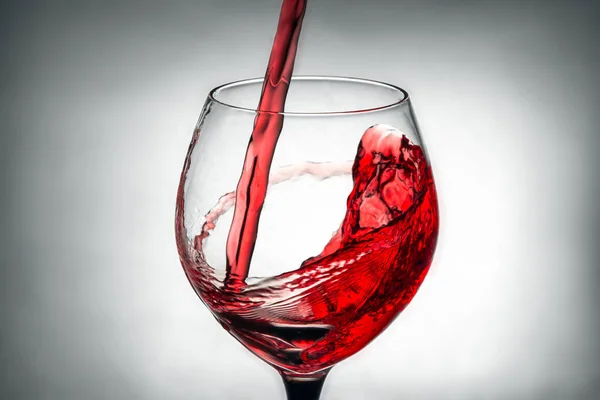 Red wine pouring splash into glass — Stock Photo, Image