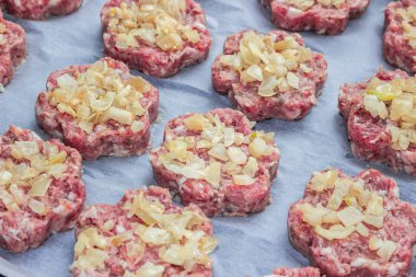 parşömen kağıt üzerinde bir çiçek şeklinde kızarmış soğanlı çiğ taze domuz pirzola