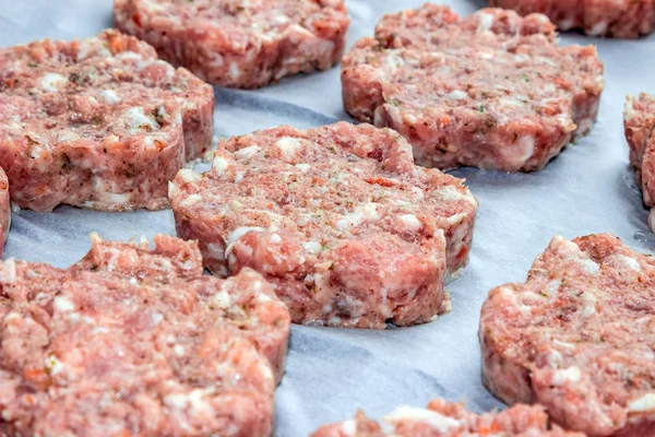 raw fresh pork cutlets in the shape of a flower on parchment paper