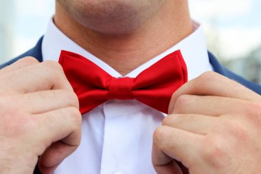 Erkekler ellerini kırmızı papyon readjusting