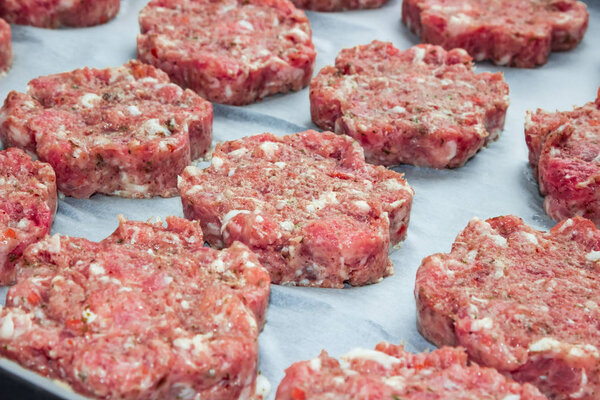 raw fresh pork cutlets in the shape of a flower on parchment paper