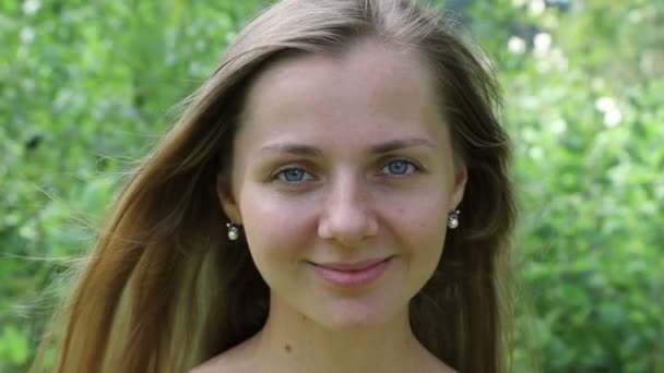 Beautiful caucasian woman smiling sweetly, face close-up. Slow motion. — Stock Video