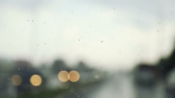 Raindrops trickle down the windshield of moving car. Slow motion — 비디오