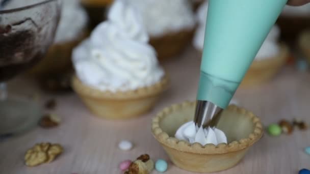 Decoración de la cesta de la torta con crema de proteína (merengue) utilizando boquilla de pastelería y bolsa . — Vídeo de stock