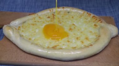 Yumurta khachapuri 'nin üzerine dökülür (Gürcistan peynirli pasta))