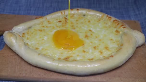 Egg is poured on khachapuri (Georgian cheese pastry) — Stock Video