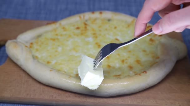 Frauenhand schmiert Butter auf Gabel von Khachapuri (georgischem Käsegebäck), Zeitlupe. — Stockvideo