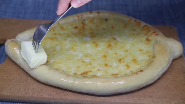 Mão da mulher esfrega manteiga khachapuri com garfo — Vídeo de Stock