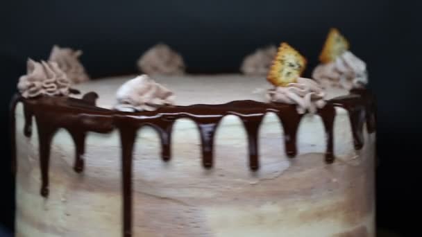 Сhef versiert de taart met koekjes. Prachtige taart bedekt met kwark room en chocolade glazuur. Snelle beweging — Stockvideo