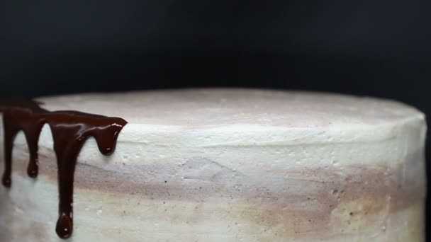 Chocolade glazuur op romige taart. Chocolade verspreidt zich over cake, close-up. — Stockvideo
