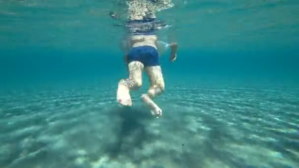 Ребенок плавает в море, вид под водой . — стоковое видео