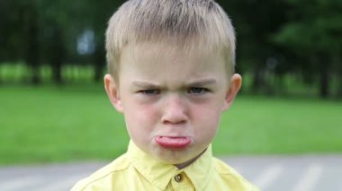 Çocuk üzgün bir çocuktur, sonra neşeli olur ve güler, yakın plan.