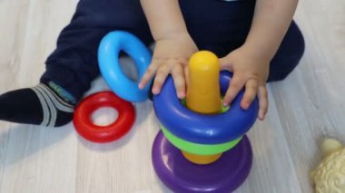 Renkli piramit toplamak için küçük çocuk (bir yaşında) çalışmalar, kapatın.
