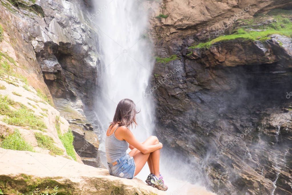 Girl next to waterfall in the mountains of Rio de Janeiro, Brazil