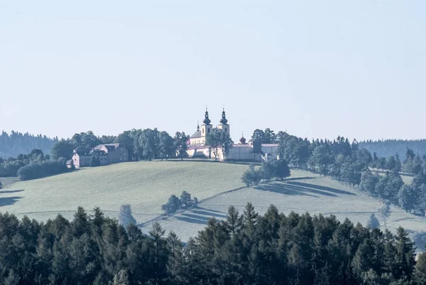 Hora Matky Bozi com igreja do anc do monastery acima da cidade de Kraliky na república checa — Fotografia de Stock
