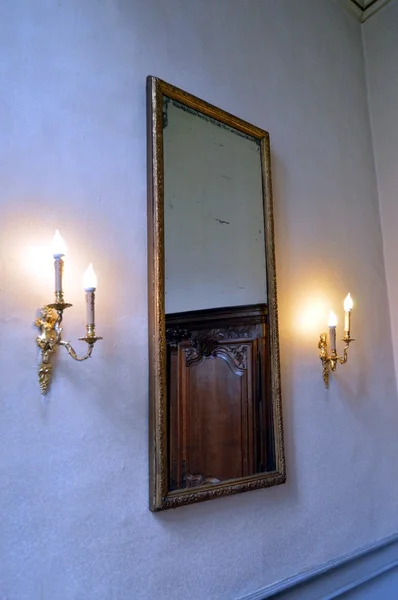 Old mirror on a white wall.