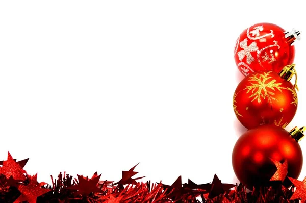 Tres bolas de Navidad y una guirnalda roja colocando verticalmente —  Fotos de Stock