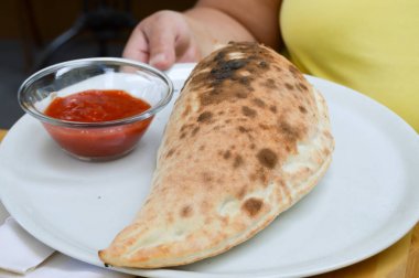 Pizza calzone üzerinde beyaz bir plat hizmet
