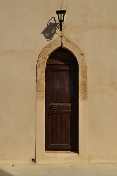 Een donker houten deur op een stenen muur — Stockfoto