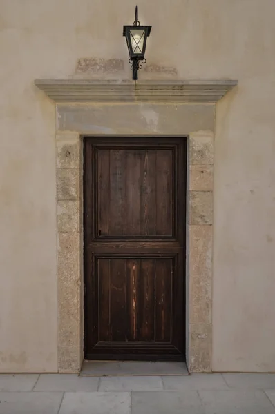 Uma porta de madeira escura em uma parede pedregosa com — Fotografia de Stock