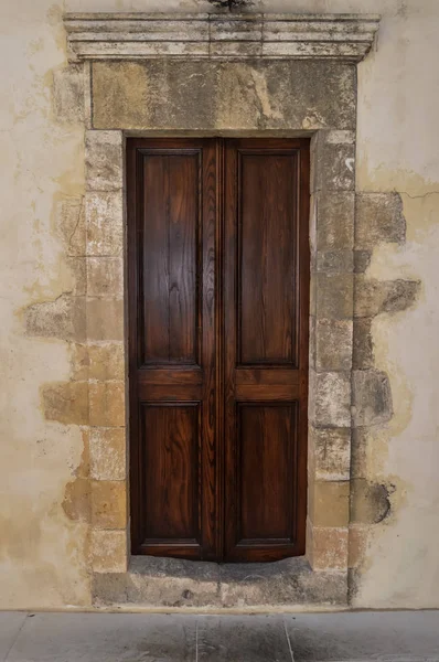 Uma porta de madeira escura em uma parede de pedra — Fotografia de Stock