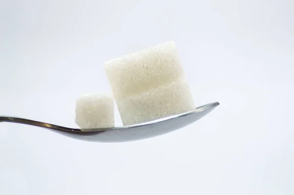 Pieces of white sugar on a stainless — Stock Photo, Image